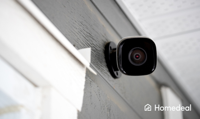 Close up van een camera van een alarmsysteem die naar voren gericht is hangt aan een buitenmuur