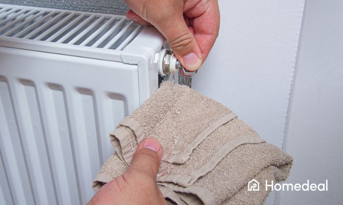 Radiator ontluchten met een handdoekje en ontluchtingssleutel