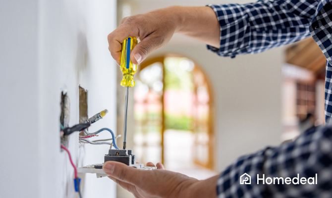 Elektricien installeert een nieuw stopcontact in een muur