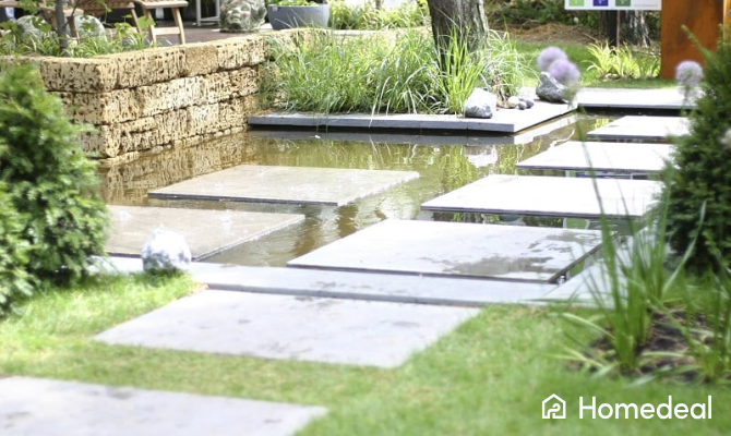 Tuin met vierkante tuintegels rondom water