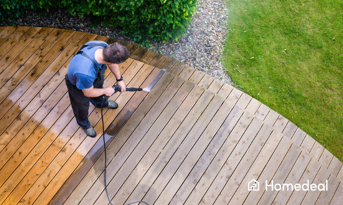 Tuinman knapt tuin op - spuit houten vlonder schoon