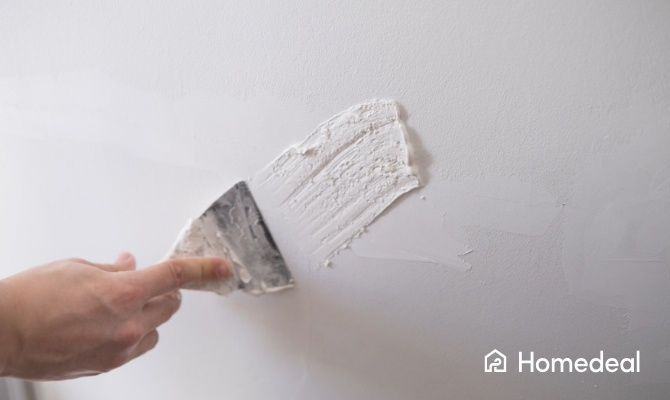 Pleisterwerk herstellen aan een beschadigde binnenmuur met herstelmateriaal en gereedschap