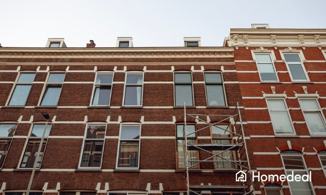 Rijwoning met steiger tegen de gevel, voorbereid op gevelrenovatie van een bakstenen voorgevel.