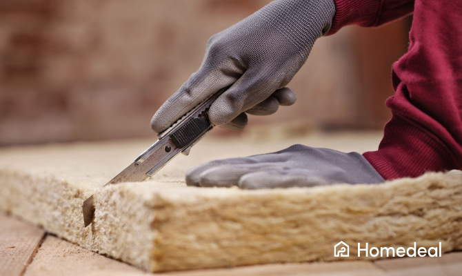 Close up persoon met handschoenen snijdt door glaswol isolatiemat