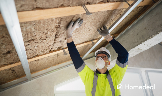 Isolatiespecialist bevestigt steenwol isolatie aan de binnenzijde van een dak