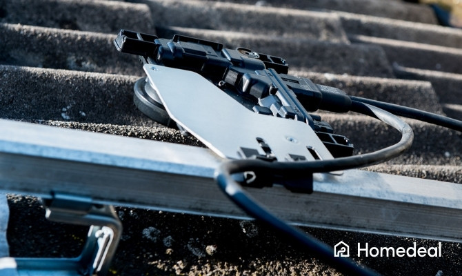 Close-up van een micro-omvormer op een dakconstructie, onderdeel van de elektrische aansluiting tussen zonnepanelen en het energiesysteem.