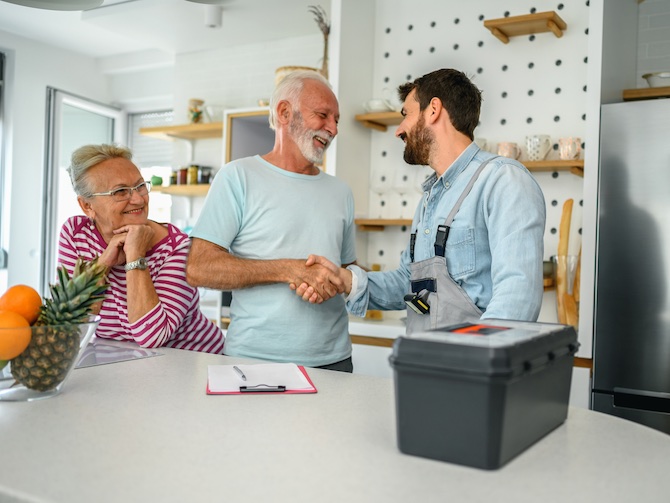 Loodgieter en huiseigenaren bespreken de offerte van de loodgieter. 