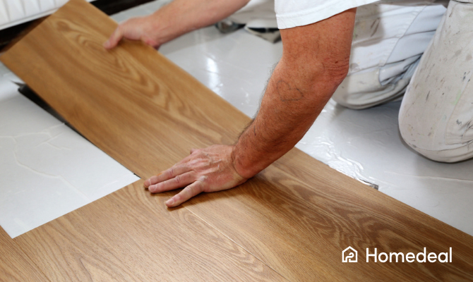 Vakspecialist legt een pvc vloer gemaakt van stroken met houtpatroon