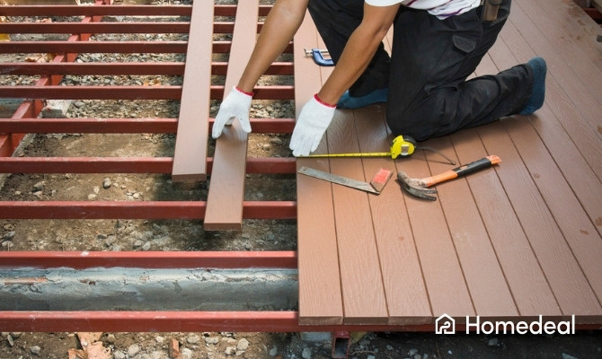 Aanleg van de fundering voor een houten terras met onderconstructie en terrasplanken in opbouw.