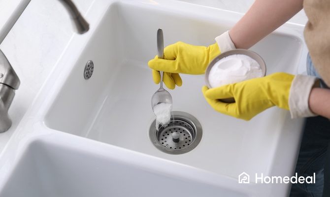 Persoon is de afvoer aan het ontstoppen met baking soda