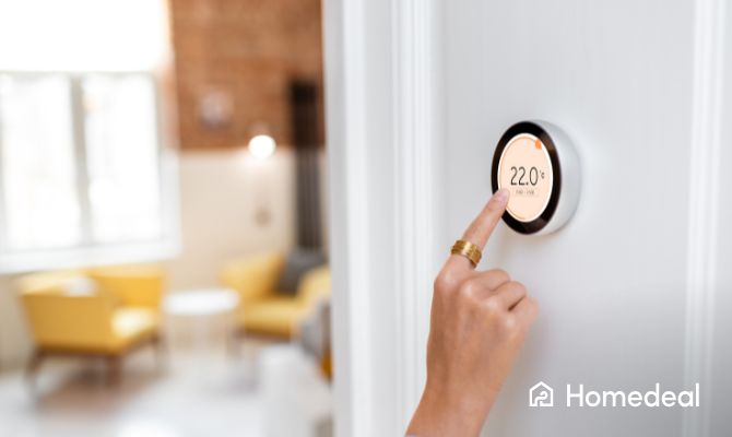 Vrouw bedient een slimme thermostaat die op de muur zit