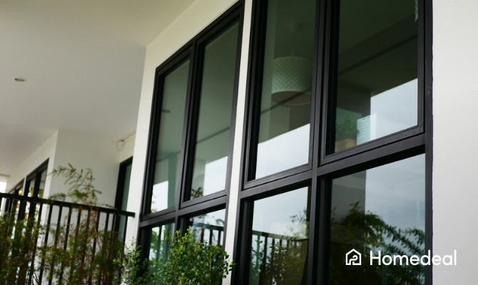 Moderne woning met zwarte aluminium ramen en grote raampartijen aan de gevel.