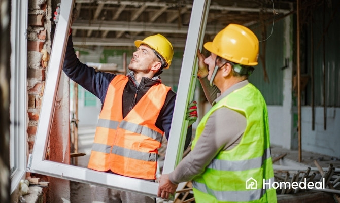 Vakmannen vervangen ramen in een renovatiewoning en plaatsen een nieuw raamkozijn in de gevel.